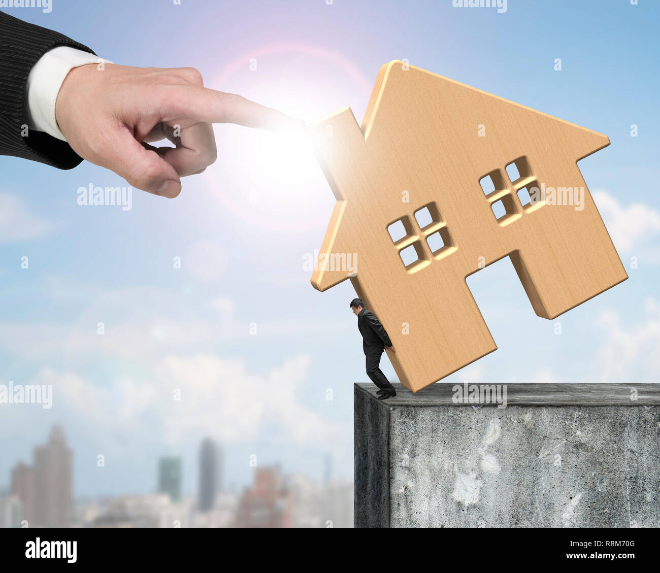 Man holding maison en bois au bord du mur de béton haut avec une autre grosse main aidant à arrêter de tomber. Banque D'Images