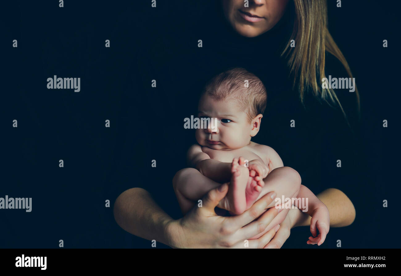 Bébé posant nue dans les bras de sa mère Photo Stock Alamy