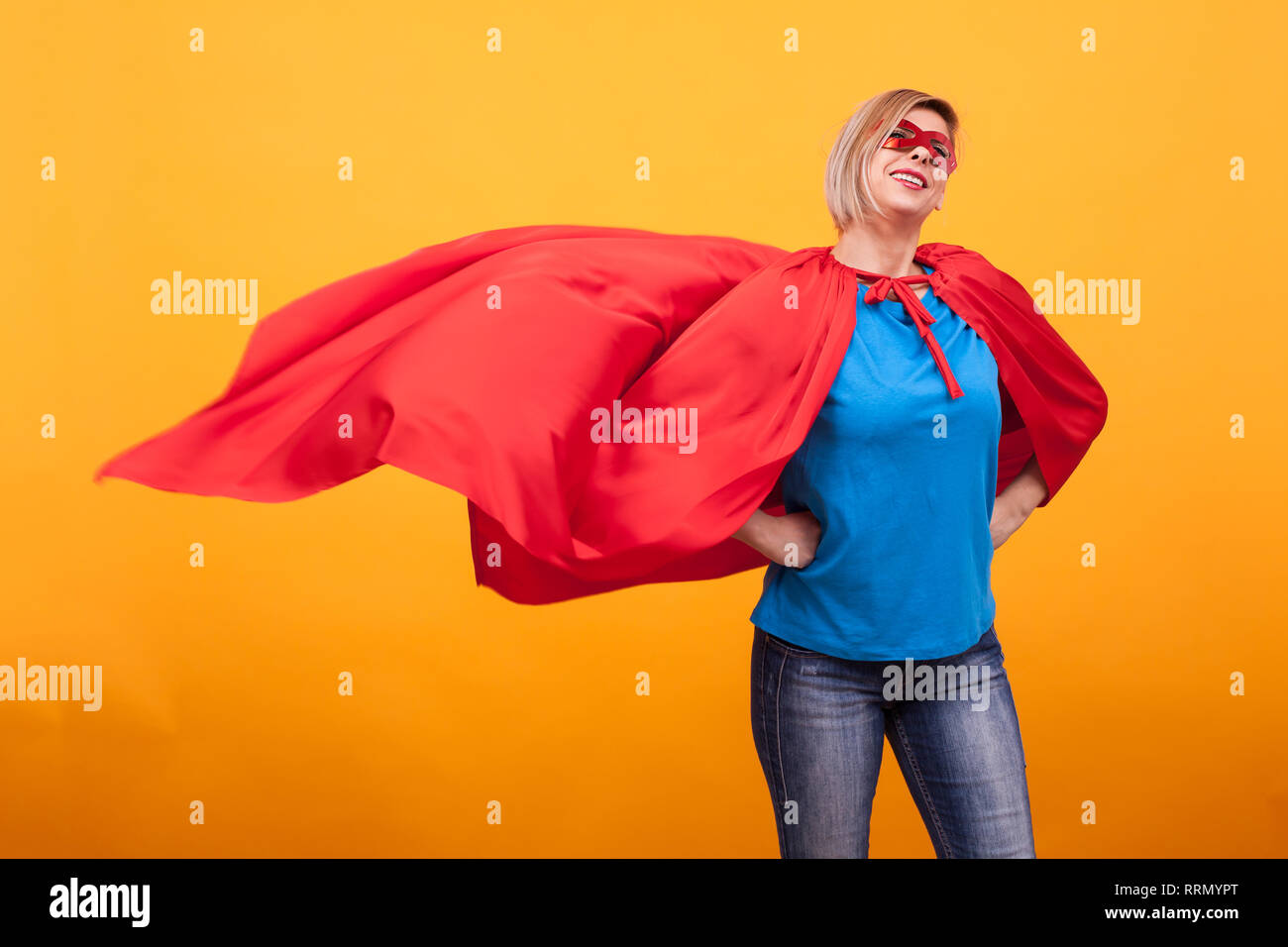 Jeune et belle femme blonde habillée comme superheroine avec cape rouge  dans l'air. Masque rouge. Femme super pouvoirs. Masque rouge Photo Stock -  Alamy