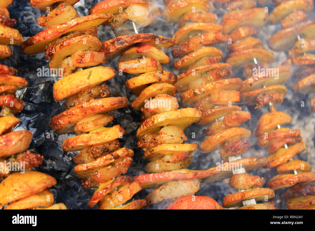 Shashliks à partir de morceaux de pommes de terre et bacon. La cuisson des pommes de terre et bacon en feu. Pique-nique à la nature. Déjeuner barbecue. Brochettes de pommes de terre marinées Banque D'Images