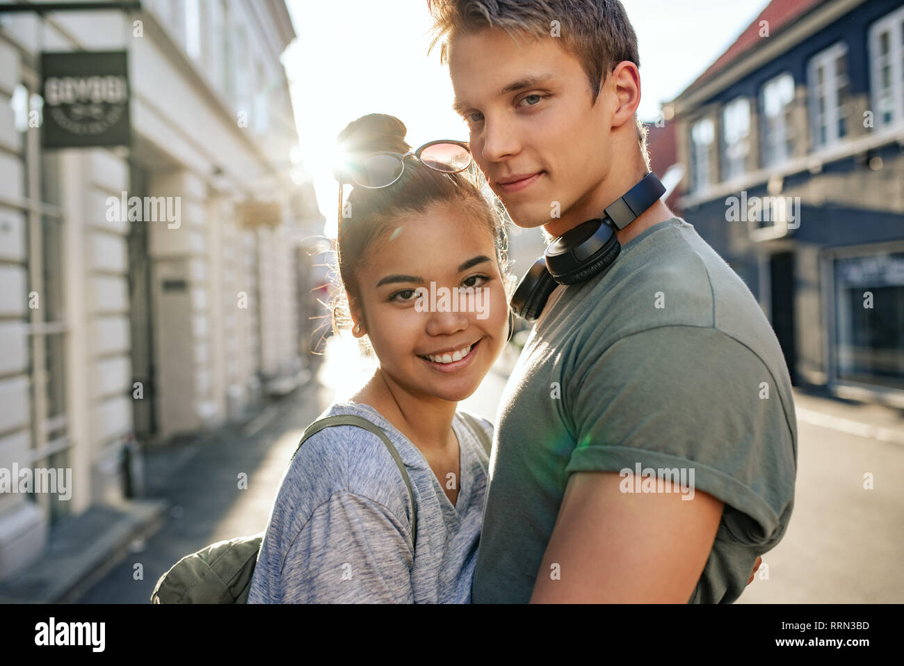 Smiling young couple hugging les uns les autres sur une rue de la ville Banque D'Images