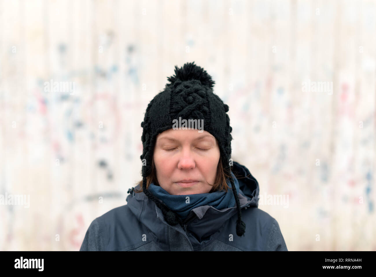 Portrait d'une femme avec les yeux fermés sur la rue par une froide journée d'hiver Banque D'Images