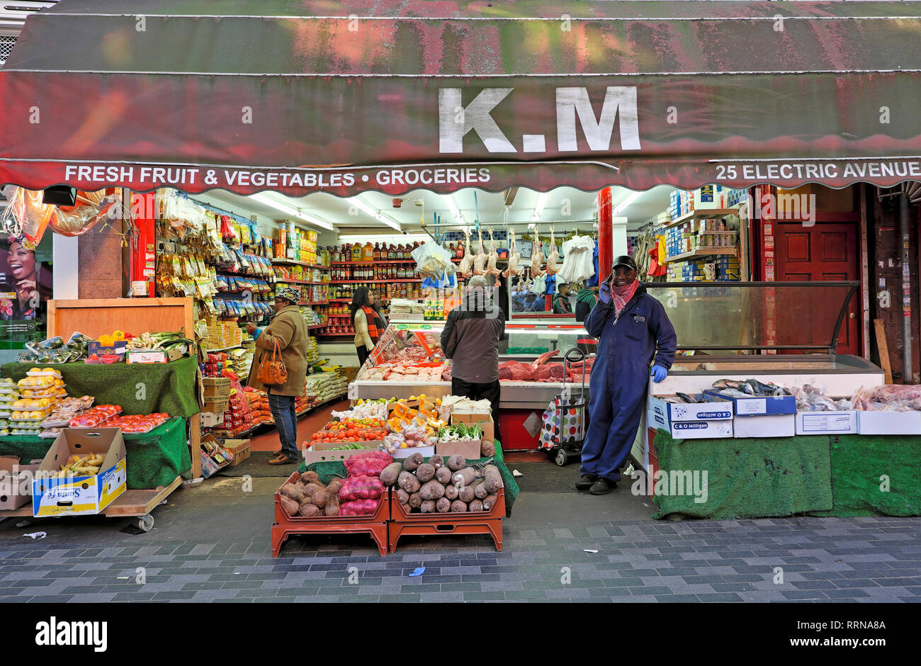 K.M marché de rue Brixton vendant des fruits et légumes sur Electric Avenue à Brixton Sud Londres SW9 Angleterre Royaume-Uni KATHY DEWITT Banque D'Images