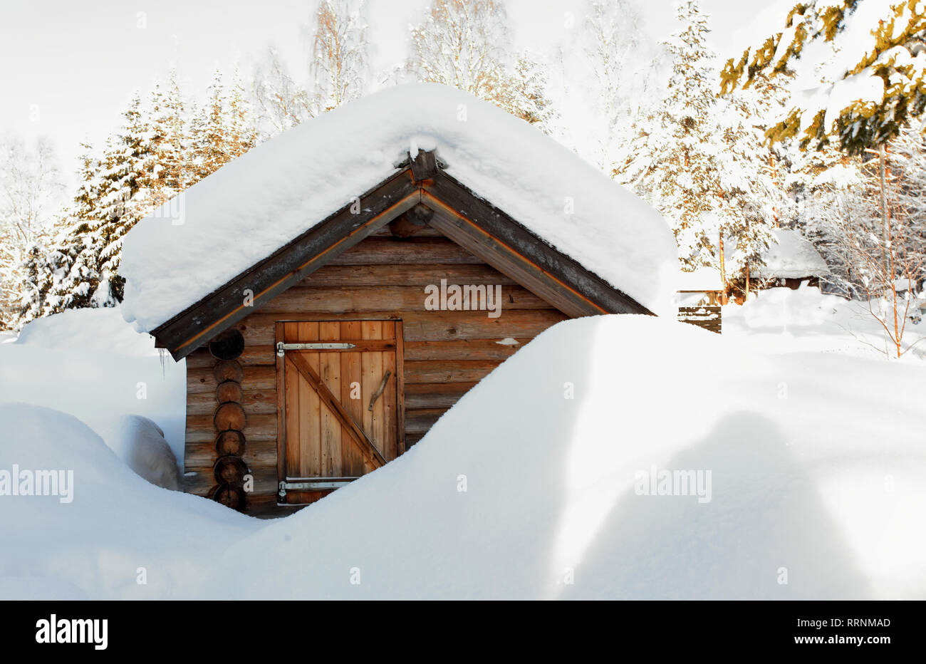 Petit chalet en bois (sauna) avec de la neige profonde, sur le toit et ses environs Banque D'Images