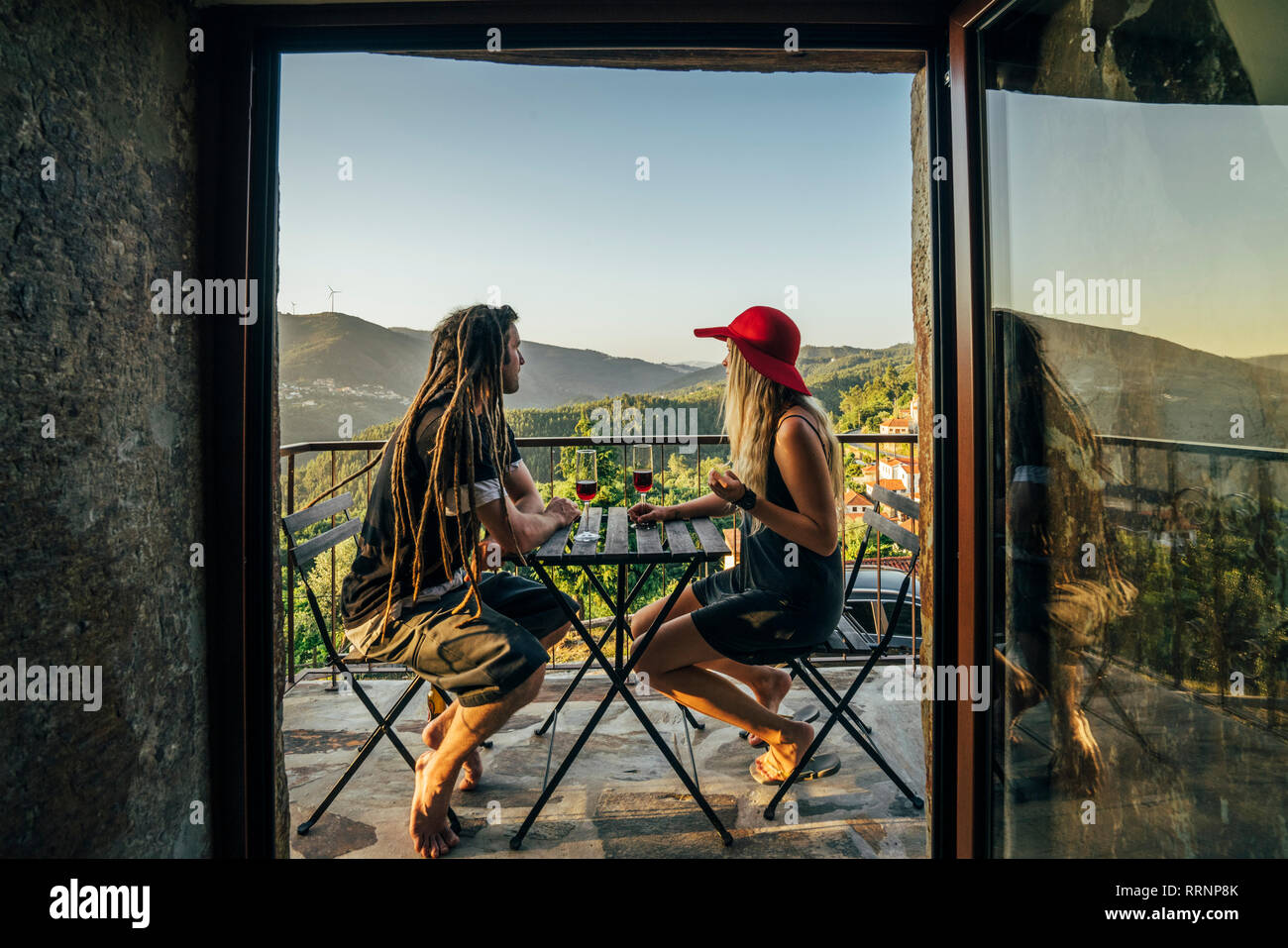 Couple relaxing, boire du vin sur balcon ensoleillé Banque D'Images