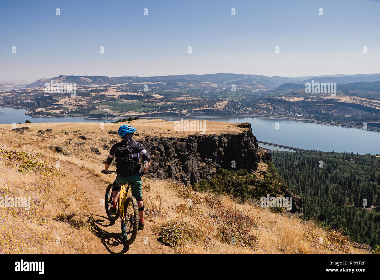 Man mountain biking, bénéficiant de vue sur la rivière Columbia cliff, Hood River, Oregon, USA Banque D'Images