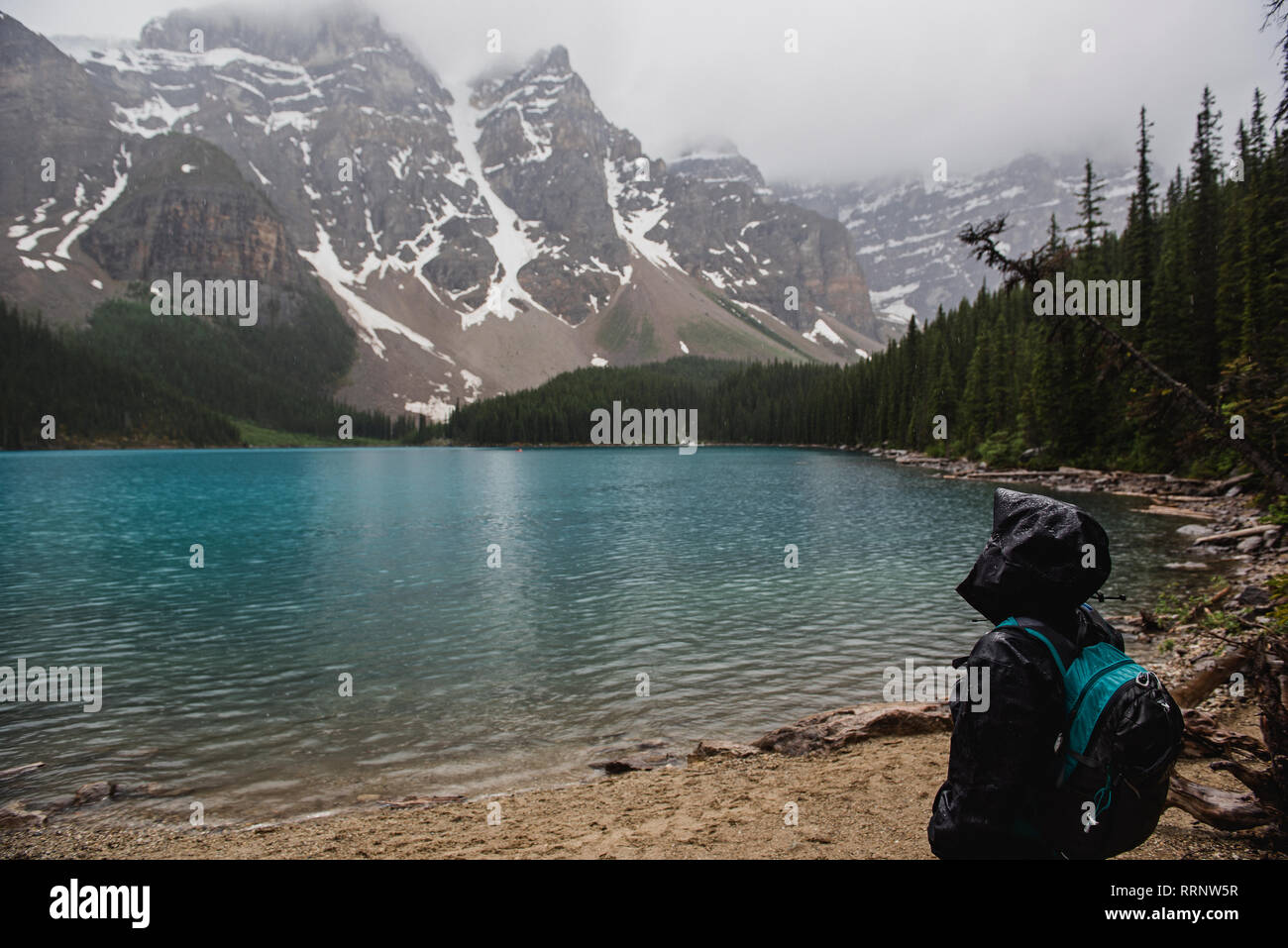 Serene randonneur dans rain jacket bénéficiant d''une montagne paisible et vue sur le lac, Banff, Alberta, Canada Banque D'Images