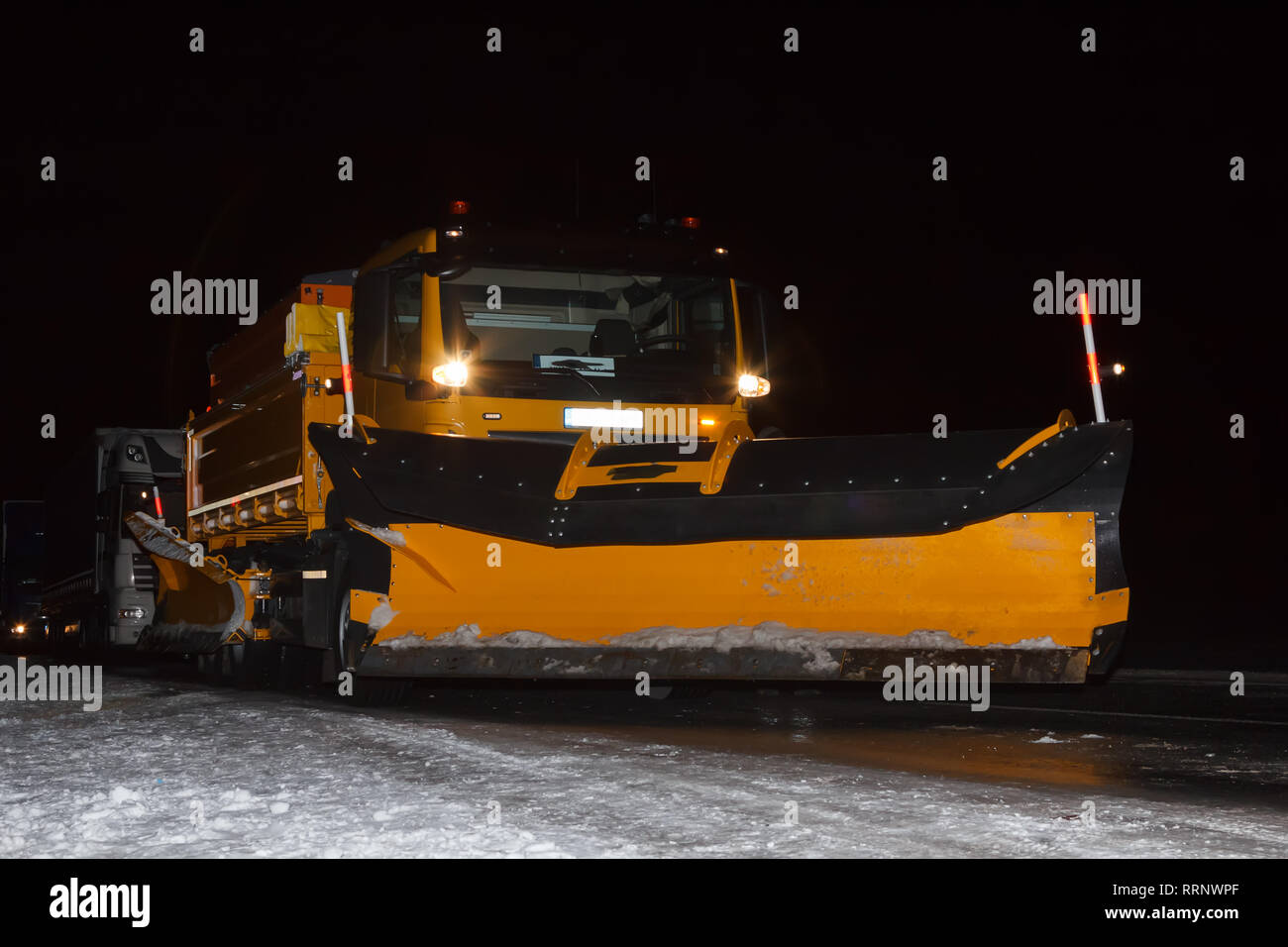 Chasse-neige de nuit sur route glissante en Février Banque D'Images