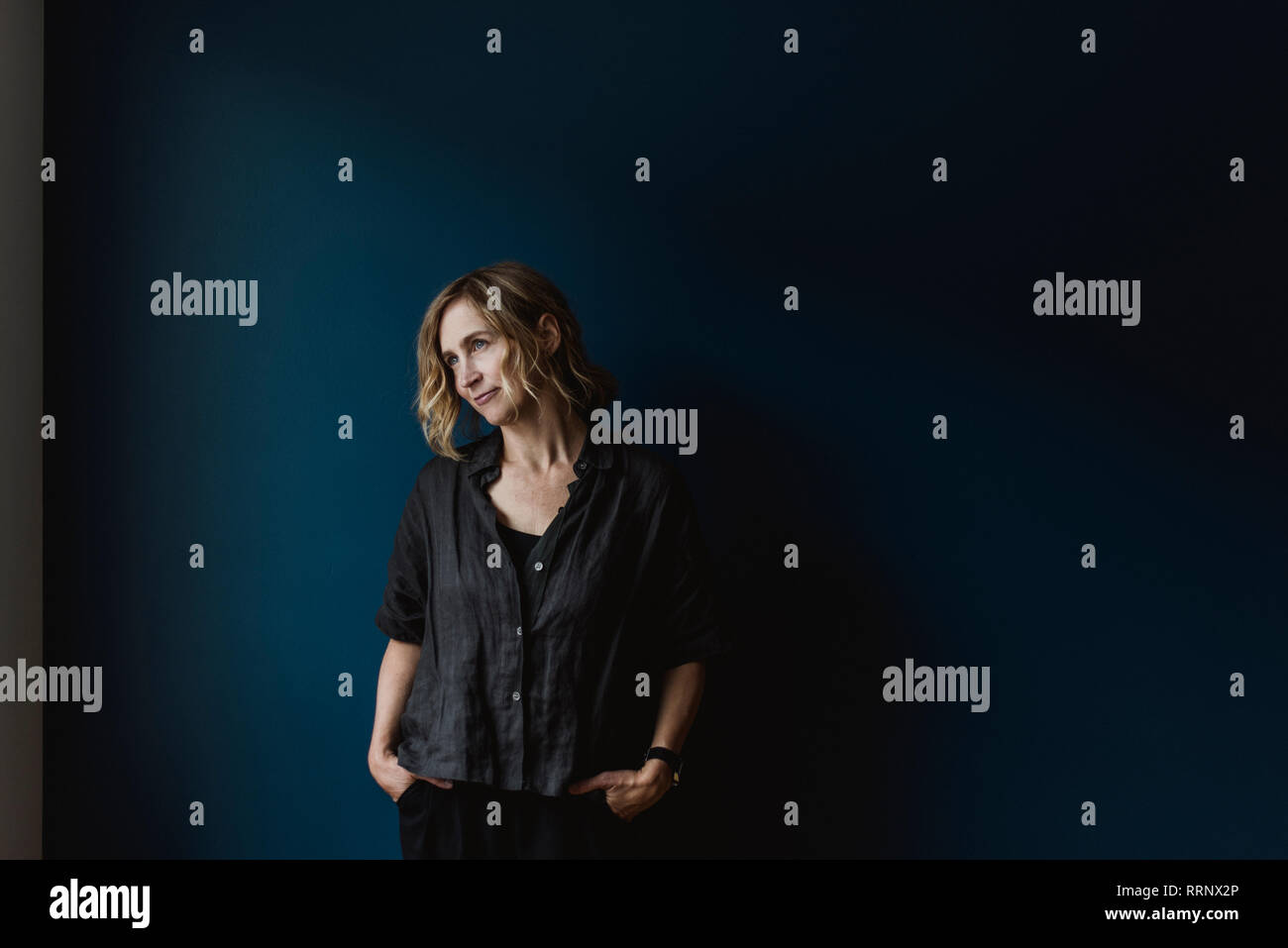 Femme sérieuse sur fond bleu Banque D'Images