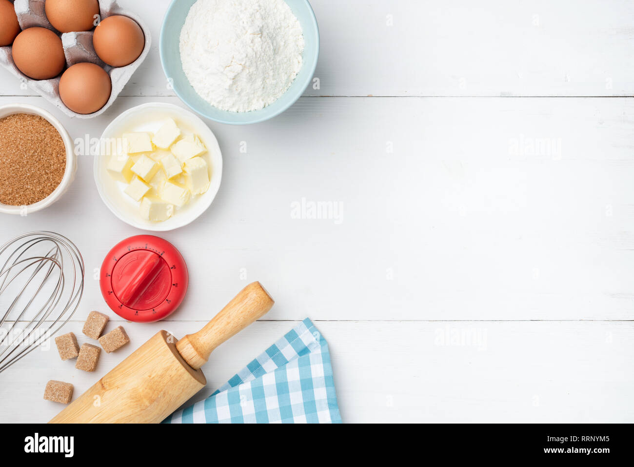 Table en bois blanc avec des ingrédients de base. Beurre, farine, oeufs, sucre et d''ustensiles de cuisine. Ingrédients pour faire des biscuits, gâteaux, pâte pr Banque D'Images