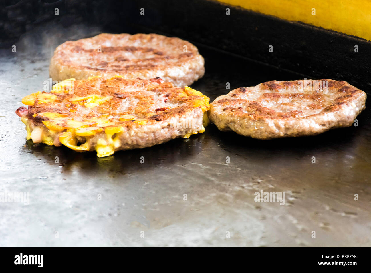 La cuisine et l'effilochage des hamburgers les hamburgers et cheeseburgers sur grill Banque D'Images