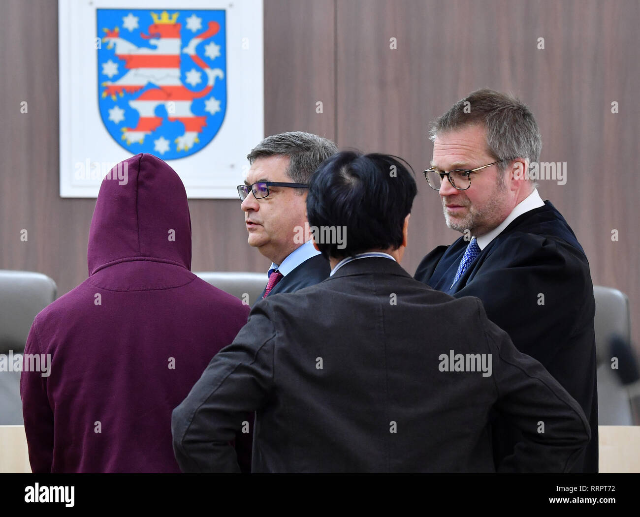 Gera, Allemagne. Feb 26, 2019. Le défendeur (l), soupçonné du meurtre d'un étudiant chinois, se tient devant l'ouverture du procès aux côtés de ses défenseurs Andreas Wiese (r) et Peter Tuppat (2e à partir de la droite) et d'un interprète dans la salle d'audience du tribunal régional. La DA est l'accusant de meurtre hors de l'avidité. C'est ce qu'on appelle la procédure de sécurité. Cela concerne le placement permanent de l'accusé dans un hôpital psychiatrique. Crédit : Martin Schutt/dpa-Zentralbild/dpa/Alamy Live News Banque D'Images