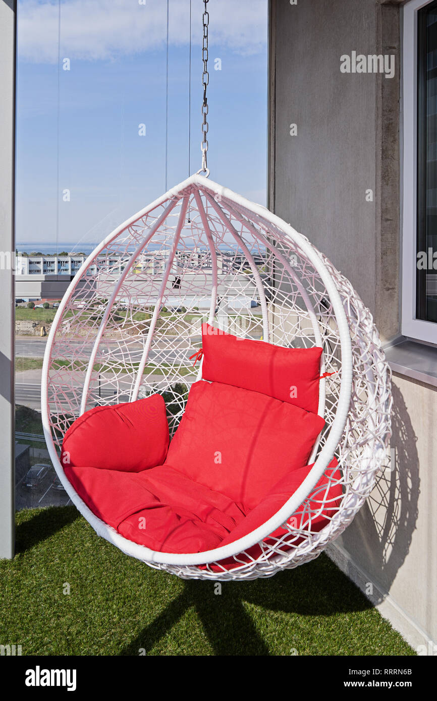 Vue d'un confortable moderne fauteuil suspendu avec oreillers rouge sur un  balcon avec une superbe vue de la ville Photo Stock - Alamy