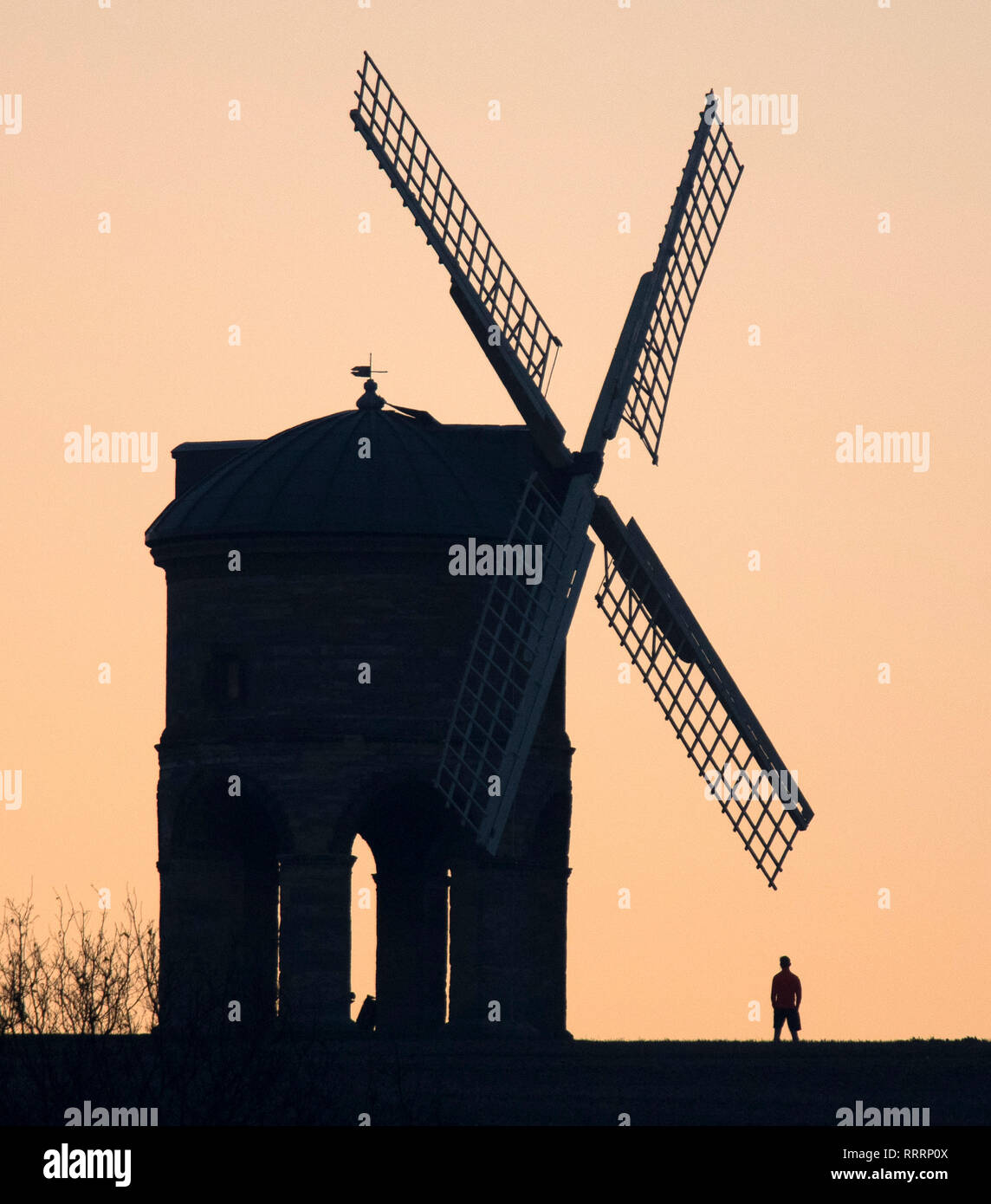 Une personne donne à la vue comme le soleil se lève derrière Chesterton Moulin dans le Warwickshire, le 26 février 2019. Banque D'Images