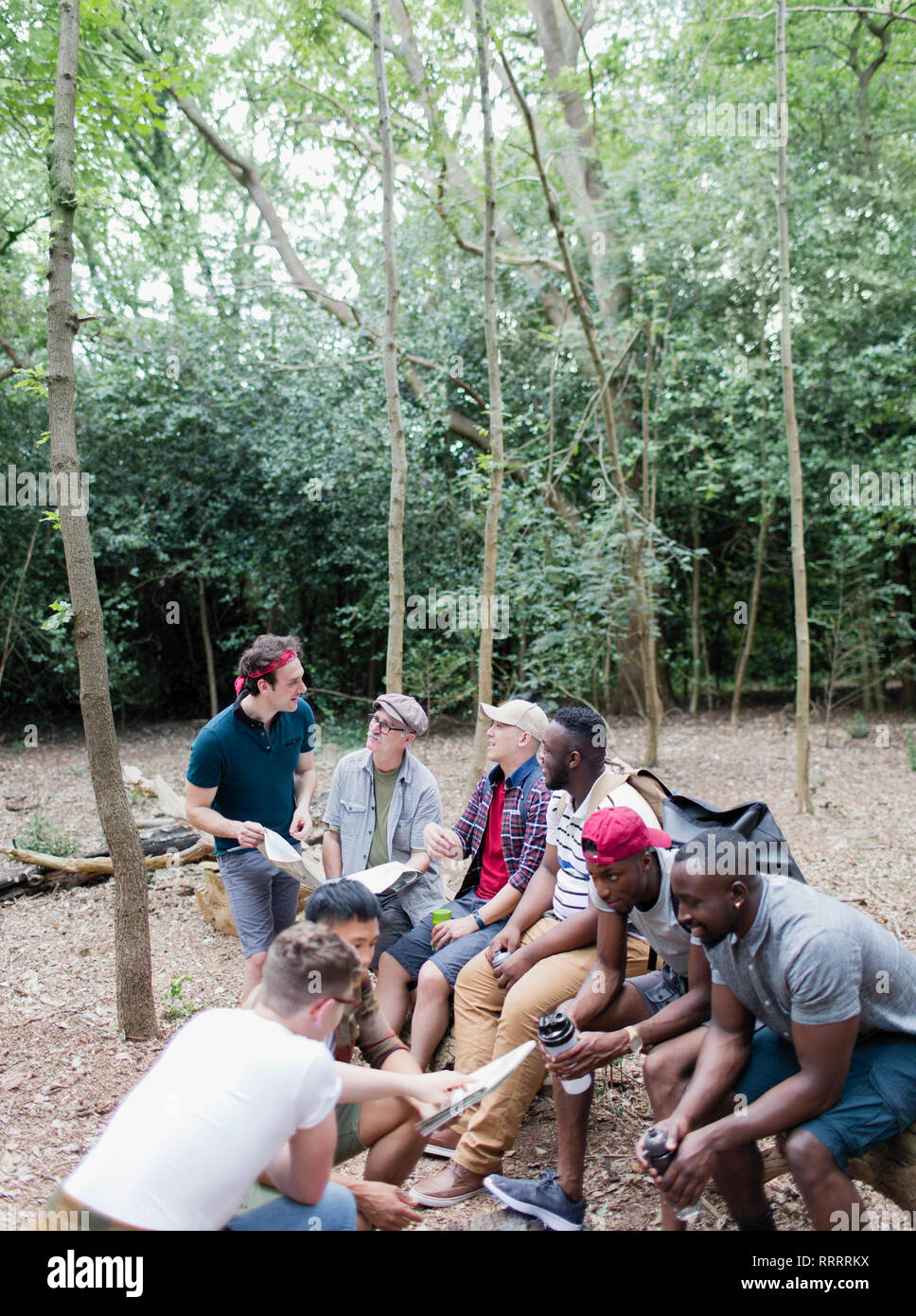 Mens group avec des cartes et des bouteilles d'eau sur la randonnée dans les bois Banque D'Images