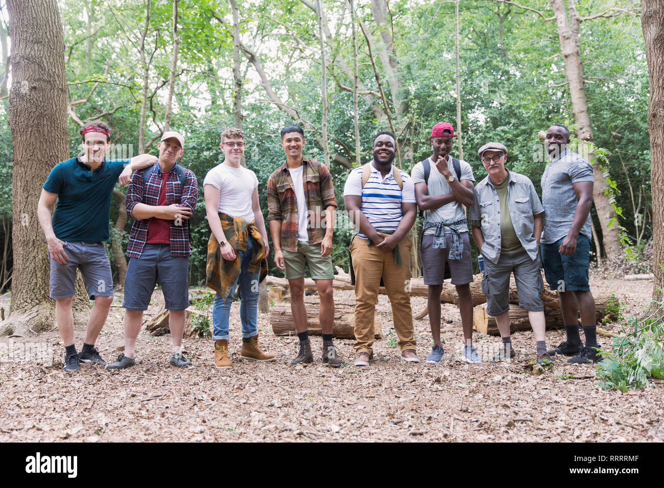 Portrait confiant mens group randonneurs standing in a row in woods Banque D'Images