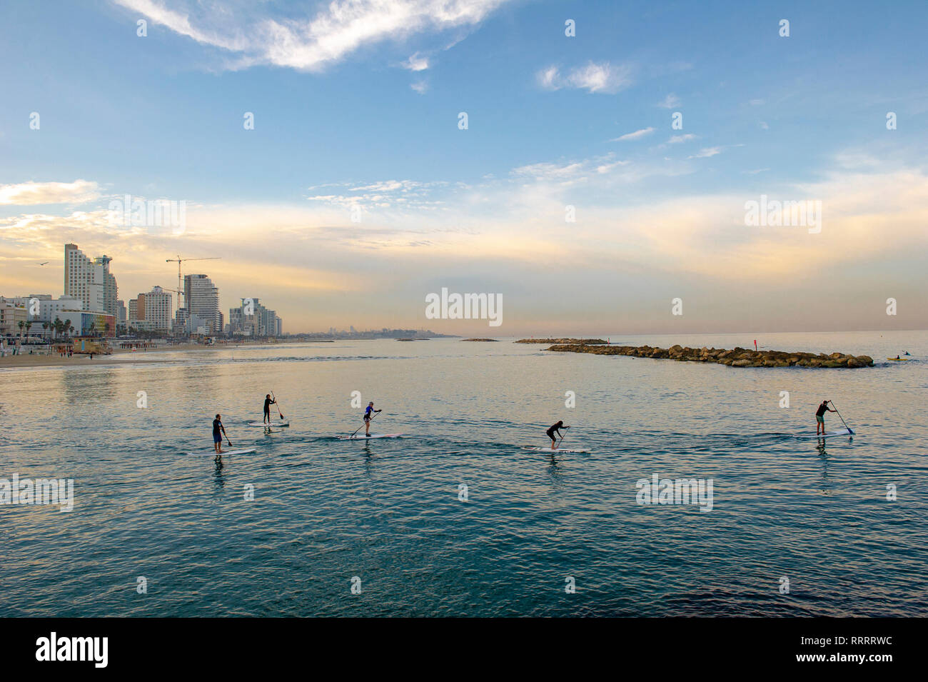 Un groupe de stand up paddle boarders pratiquer tôt le matin au large de la plage urbaine de Tel Aviv, Israël Banque D'Images