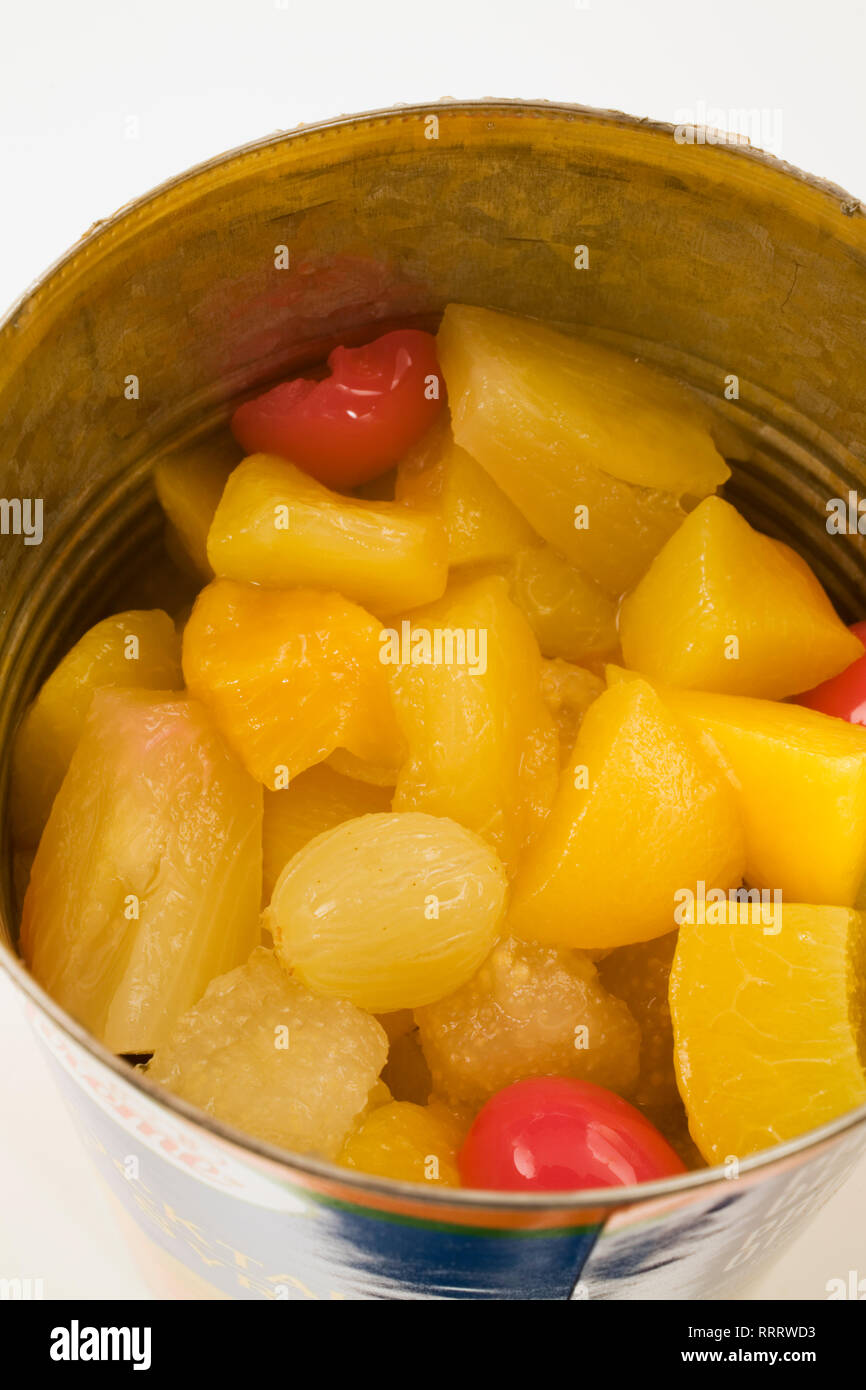 Close-up de salade de fruits avec les cerises, les raisins, les pêches et les poires dans une boîte sur un fond blanc Banque D'Images
