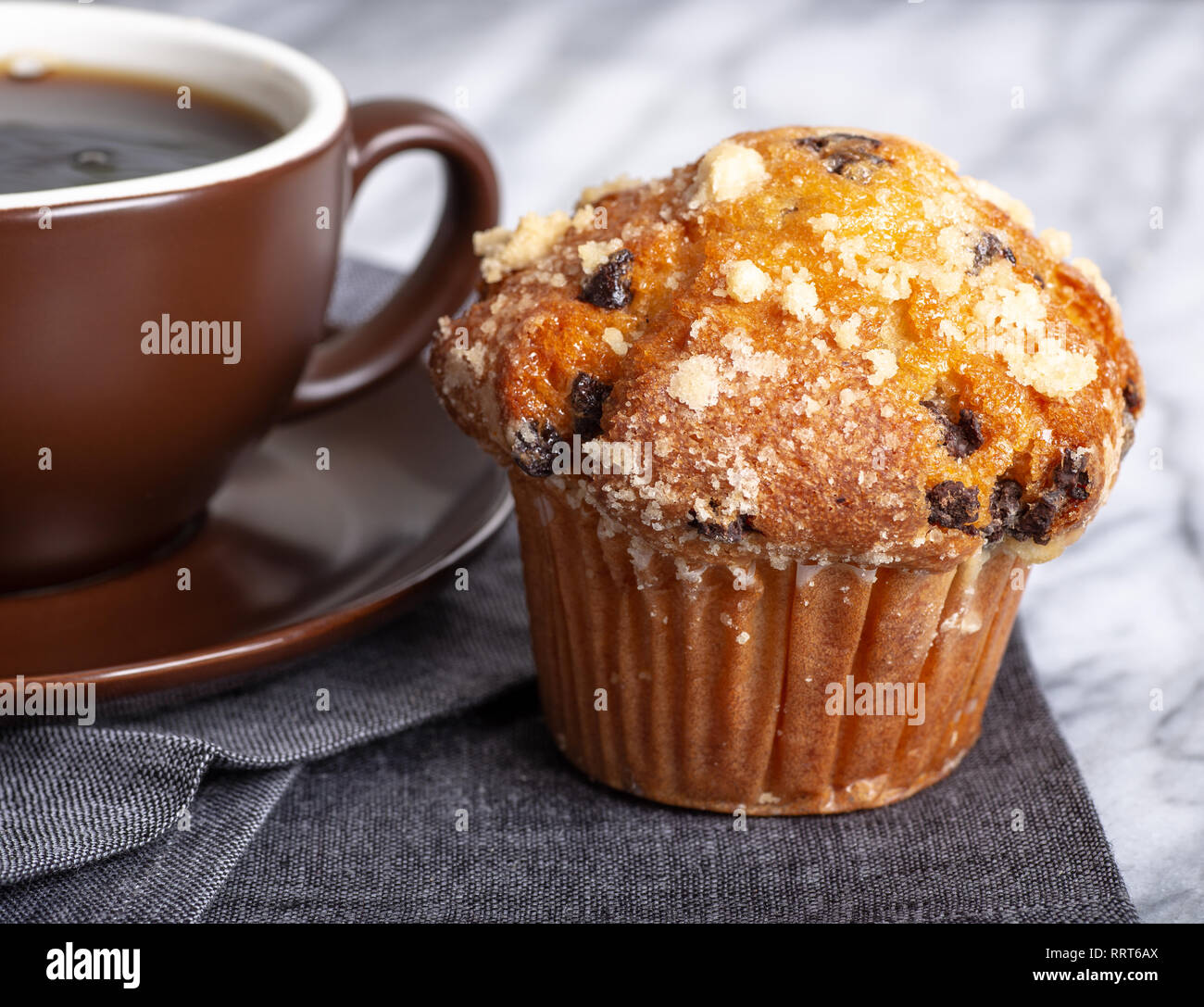 Libre d'un muffin au chocolat et une tasse de café sur une serviette gris Banque D'Images