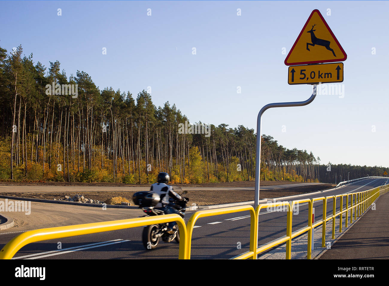 Un panneau routier motocycliste avertit qu'il y a des chevreuils ou autres animaux sauvages qui traversent la route devant vous Banque D'Images