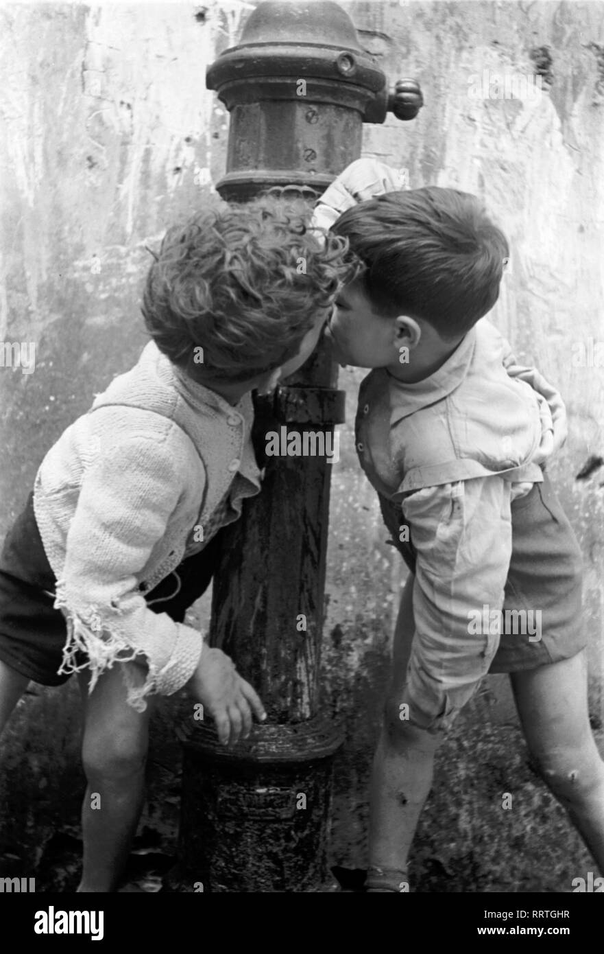 Am Brunnen - Zwei trinken une einem Jungen öffentlichen Brunnen dans Napoli, Italie 1950er Jahre. V.523-21 deux petits garçons boire d'une population bien à Naples, Italie 1950. Banque D'Images