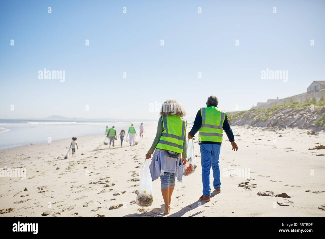 Les bénévoles le nettoyage de déchets sur la plage de sable ensoleillée Banque D'Images