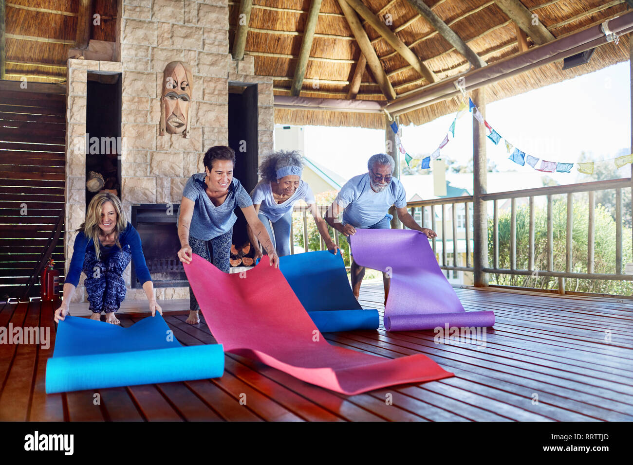 Les gens en déroulant un tapis de yoga en hut durant yoga retreat Banque D'Images