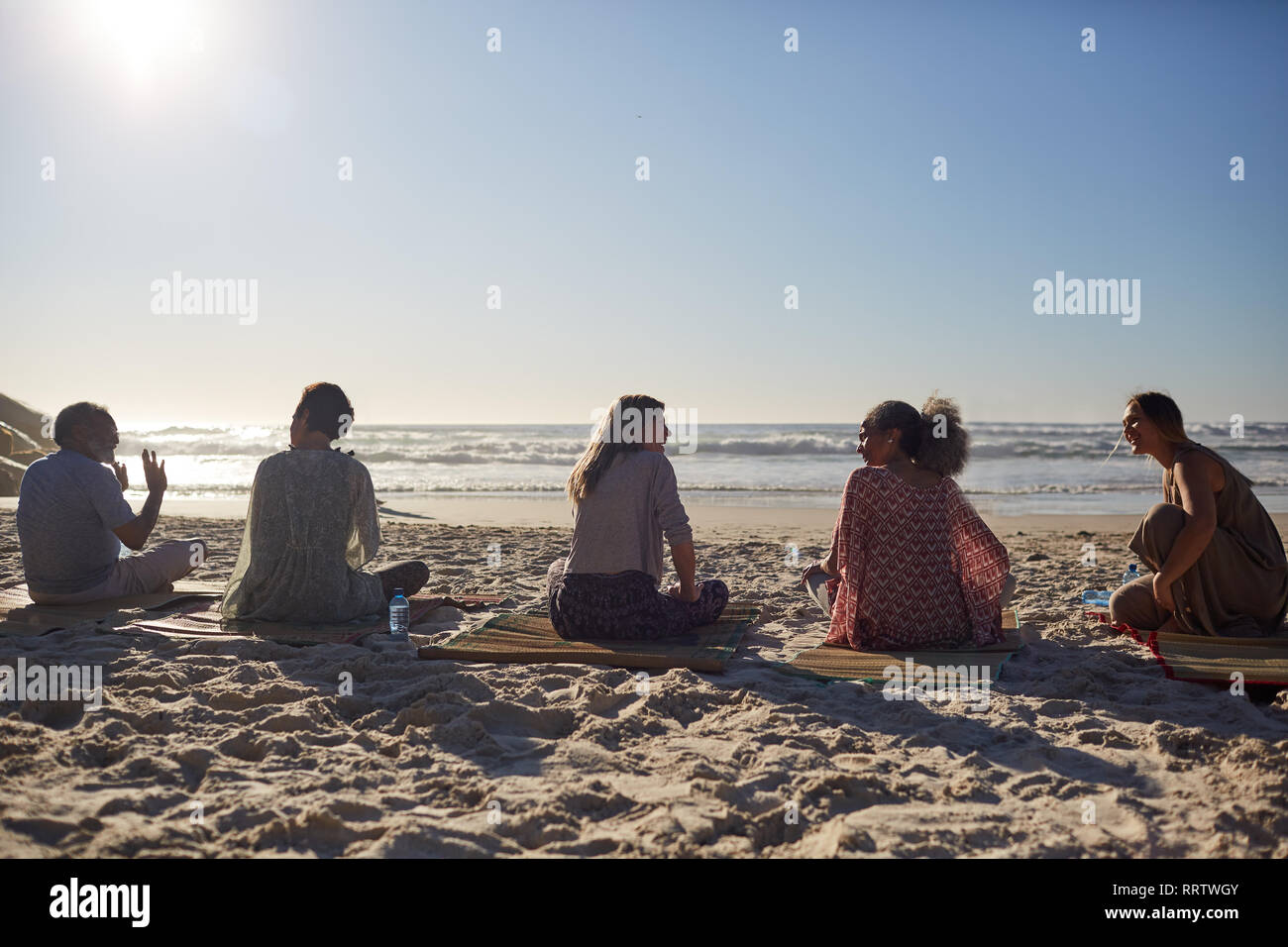 Cours de conversation sur la plage ensoleillée au cours de yoga retreat Banque D'Images