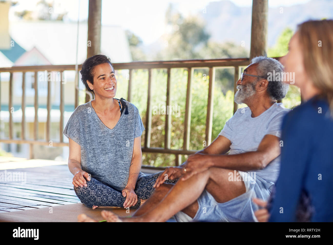 Smiling man and woman talking in hut au cours de yoga retreat Banque D'Images Smiling man and woman talking in hut au cours de yoga retreat Banque D'Images