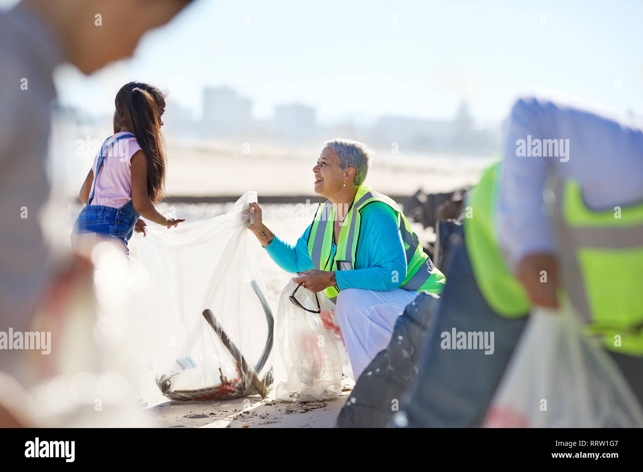 Senior woman and girl du bénévolat le nettoyage de litière à Sunny Beach Banque D'Images