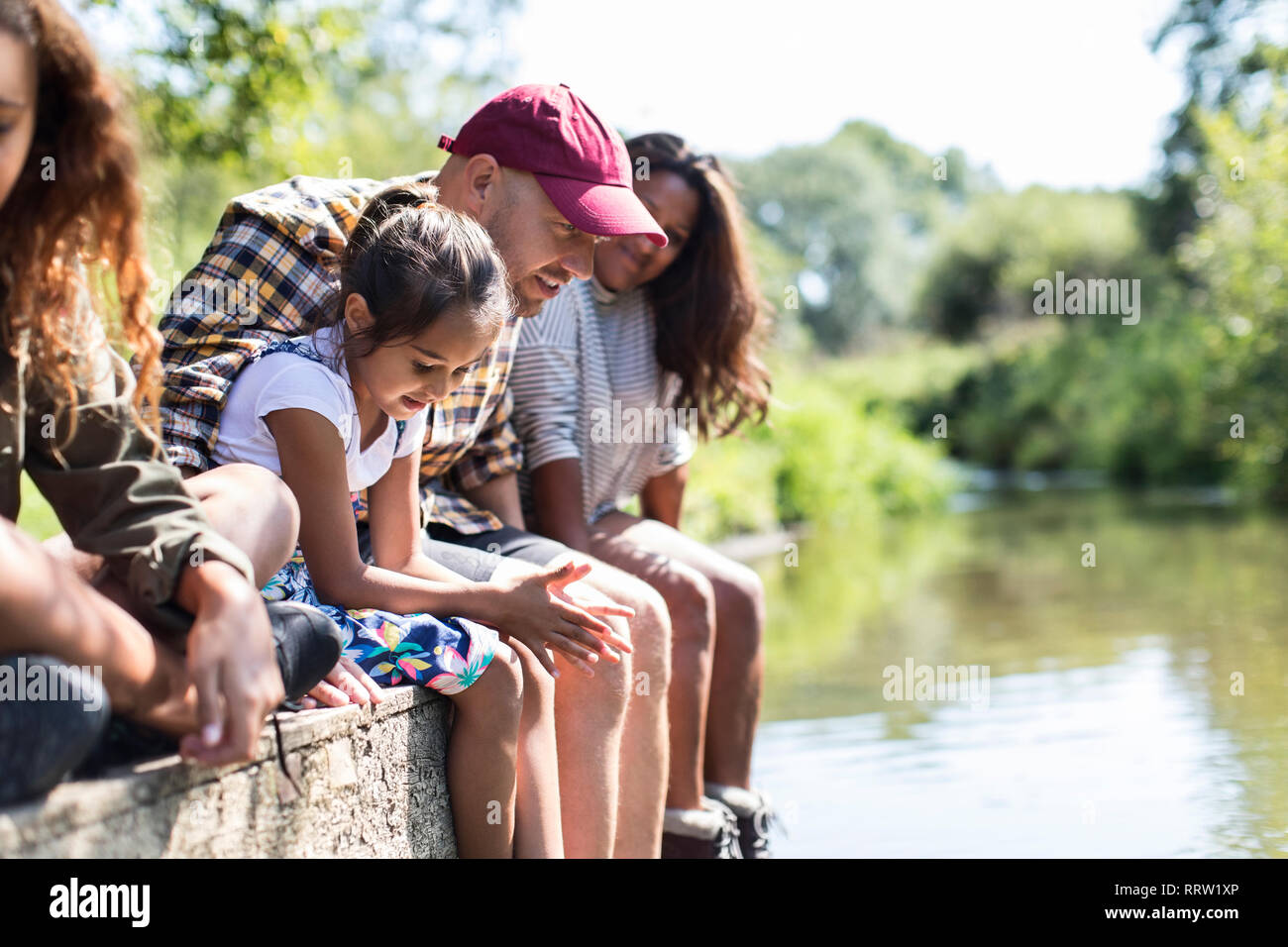 Family sitting au bord de dock riverside Banque D'Images