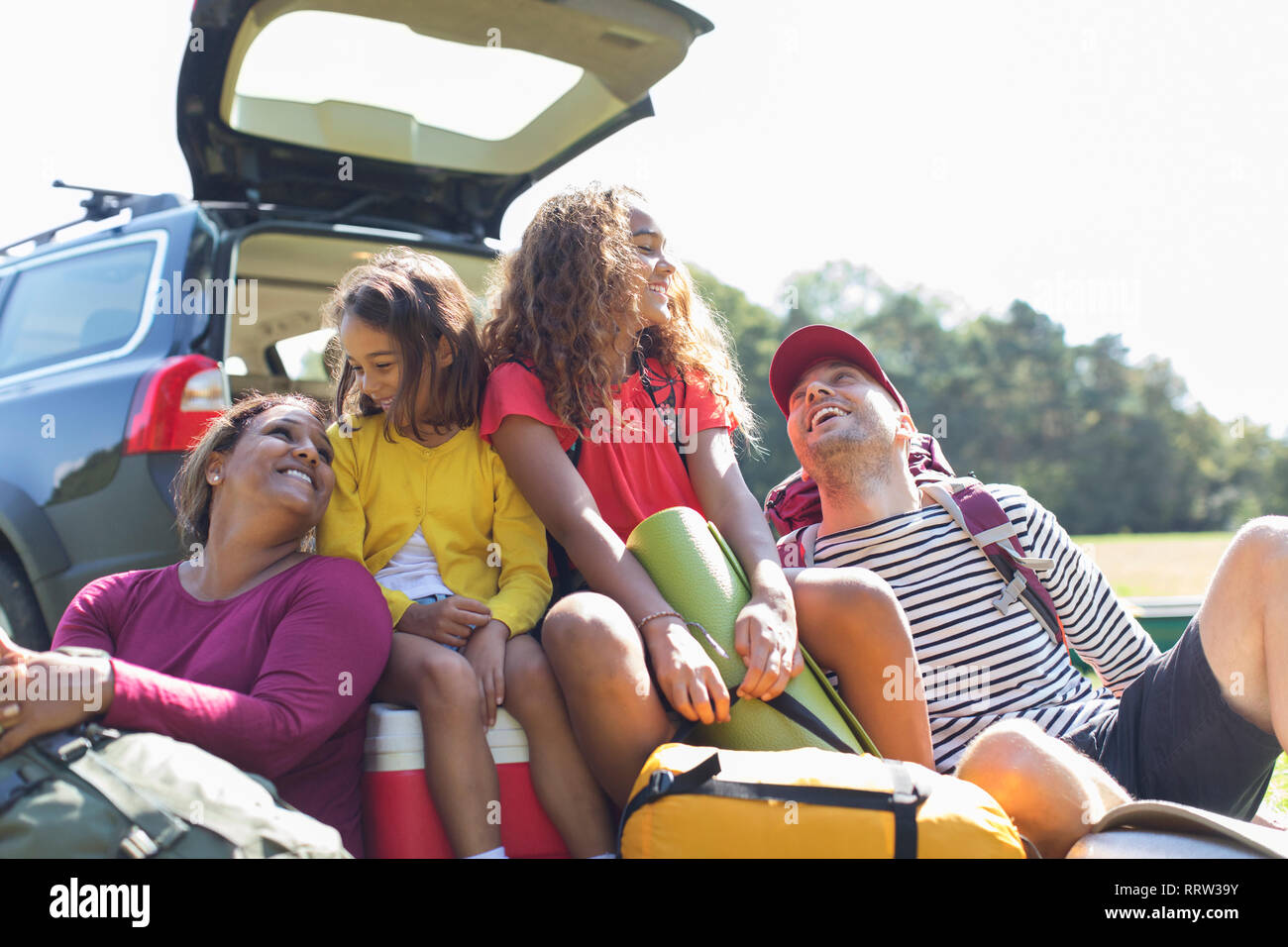 Famille heureuse avec l'équipement de camping à l'arrière du véhicule Banque D'Images