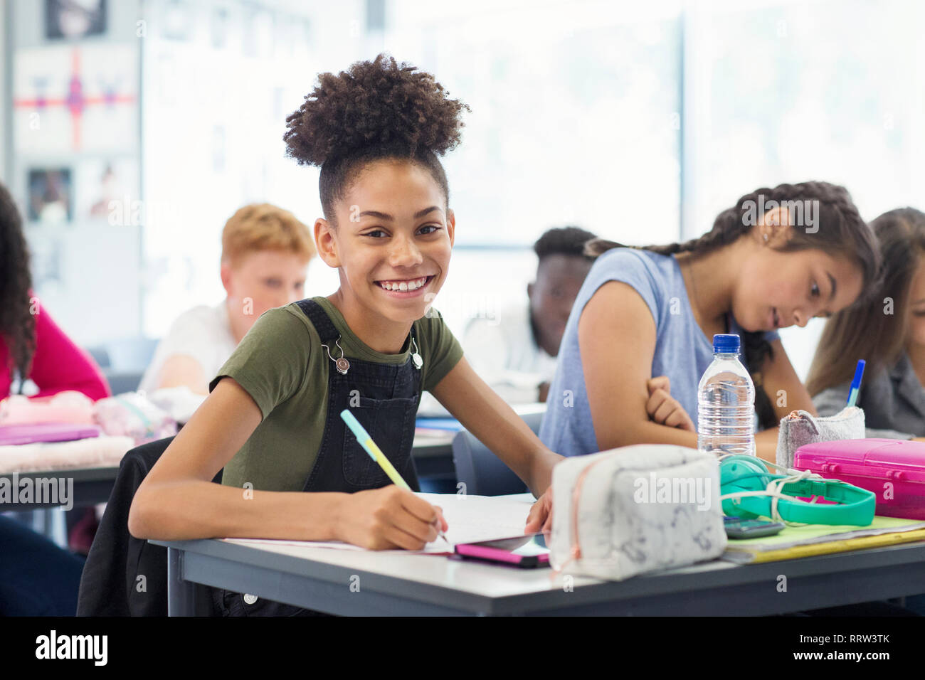 Portrait confiant junior high school student girl doing Homework in classroom Banque D'Images
