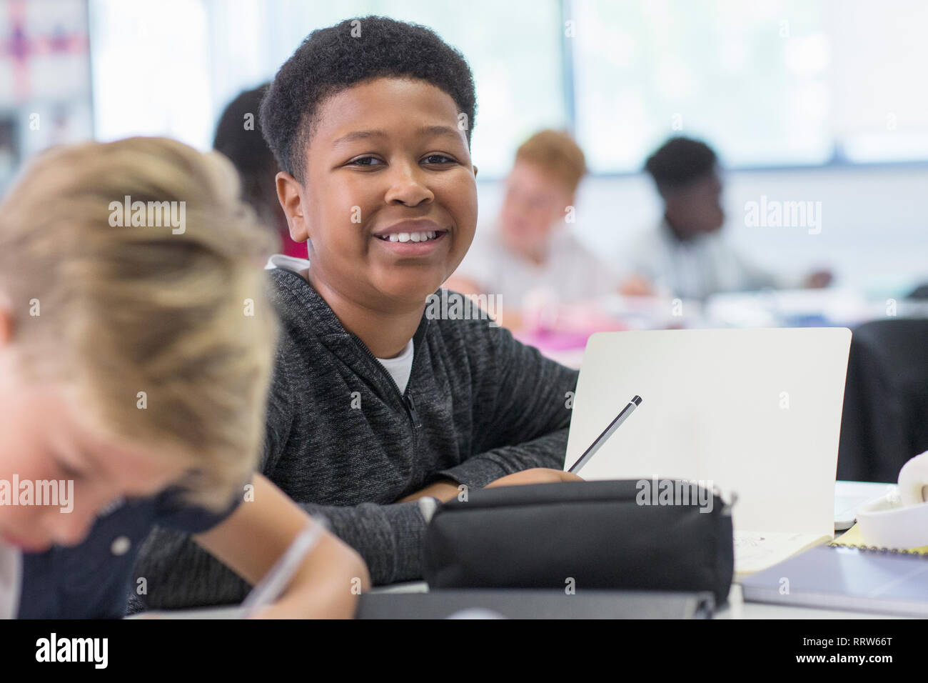 Portrait confiant junior high school boy studying in classroom Banque D'Images