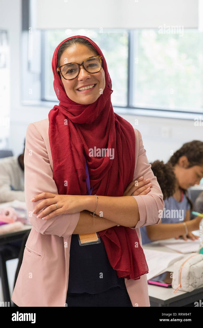 Portrait confiant enseignante portant hijab in classroom Banque D'Images