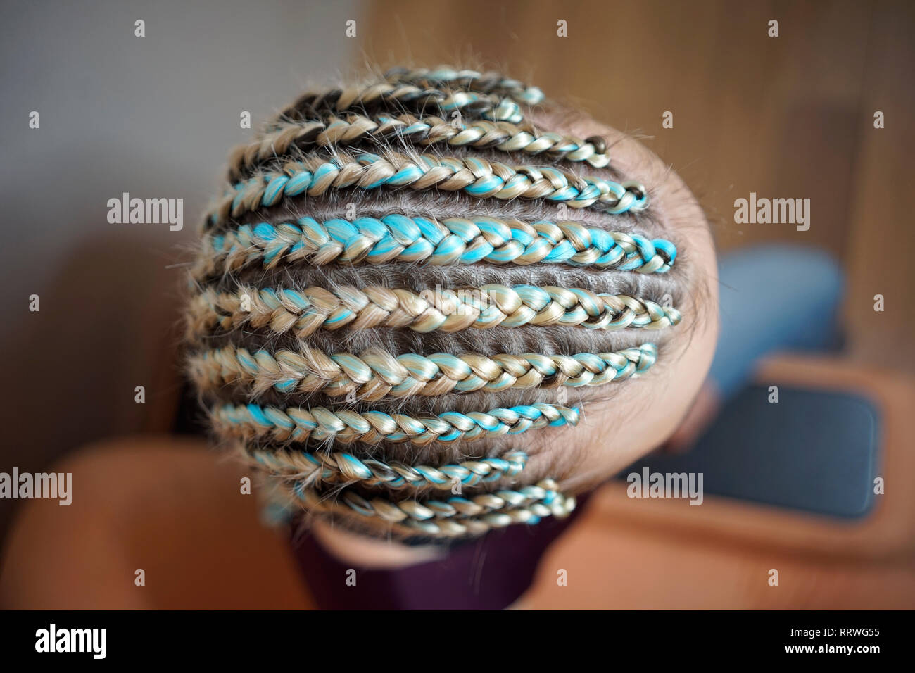 Les femmes de cornrows une femme avec une coupe sur un fond blanc, les tresses serrées dans une queue tressée, matériau artificiel tissé dans ses cheveux Banque D'Images