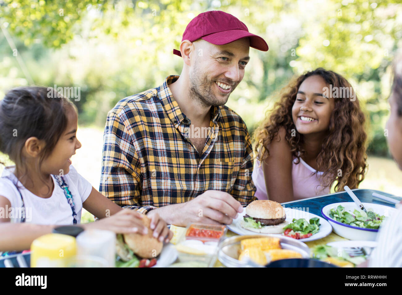 Heureux père et filles appréciant déjeuner barbecue Banque D'Images