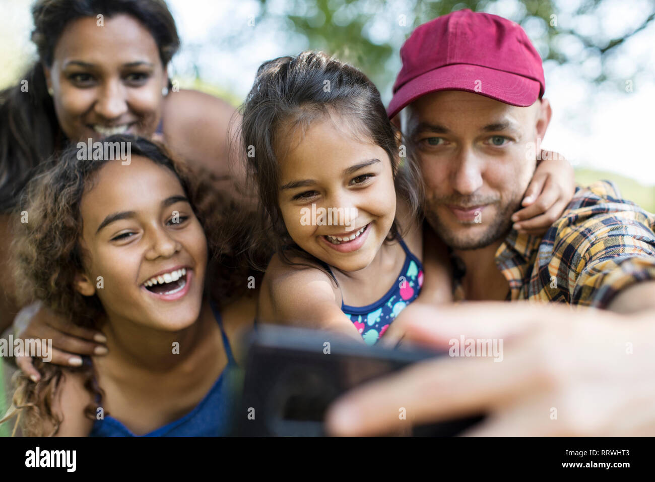 Famille heureuse en tenant avec selfies téléphone appareil photo Banque D'Images