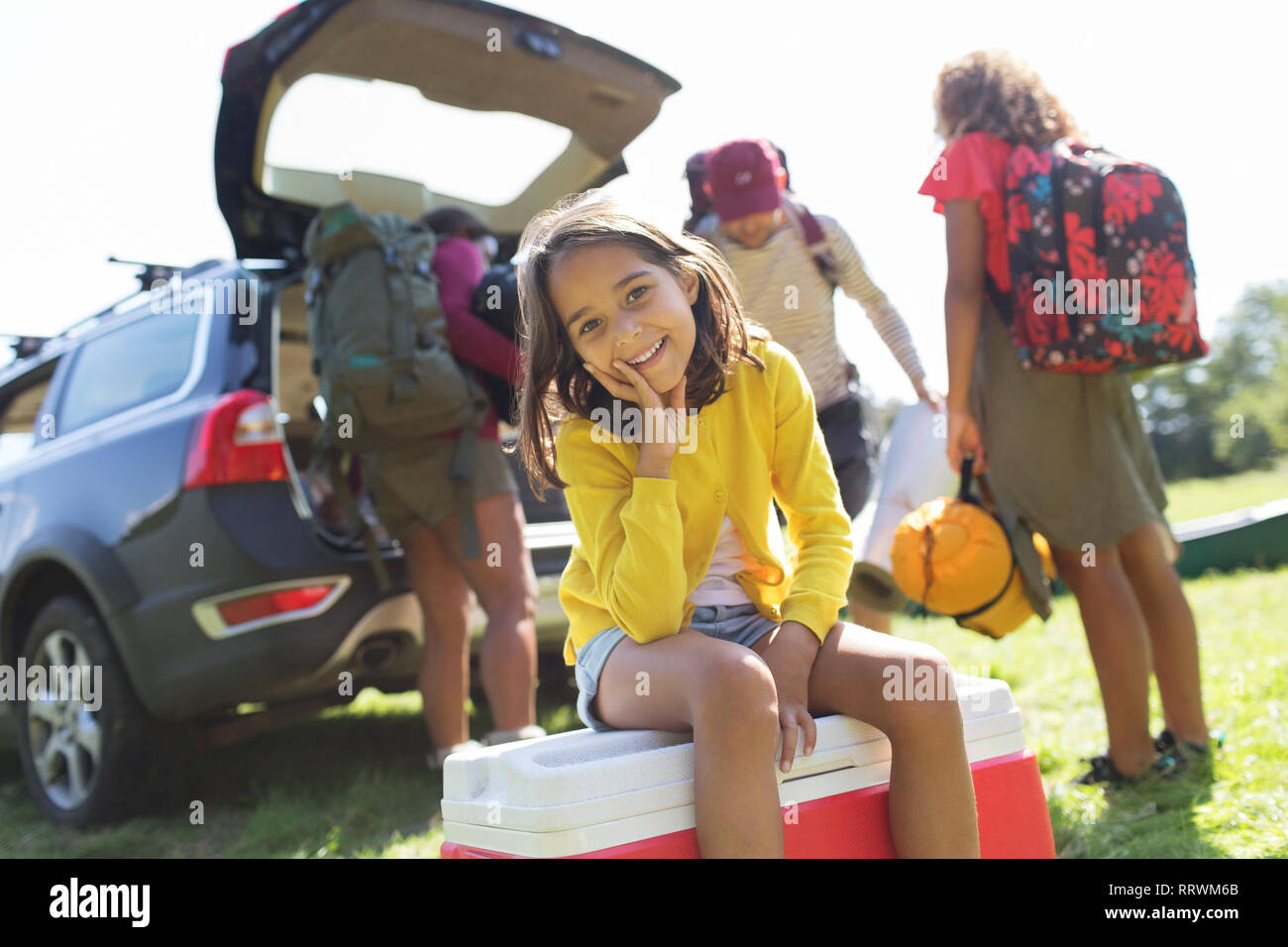 Portrait of smiling girl camping en famille, déchargement location Banque D'Images