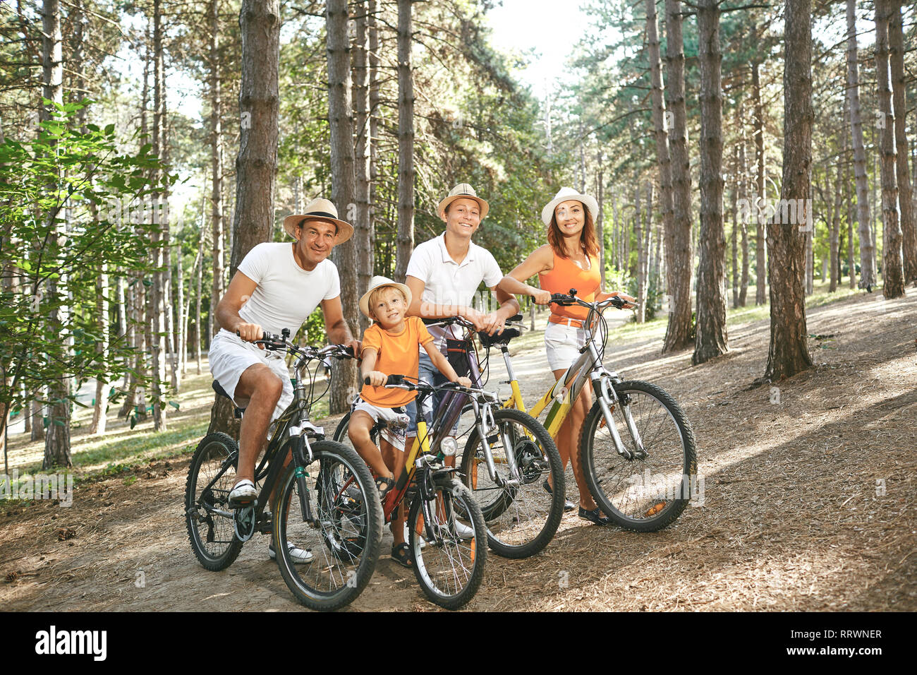 Famille heureuse sur les bicyclettes pour une promenade en parc. Banque D'Images