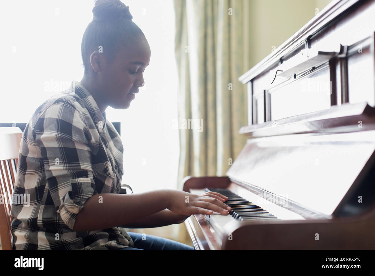 Teenage girl playing piano Banque D'Images