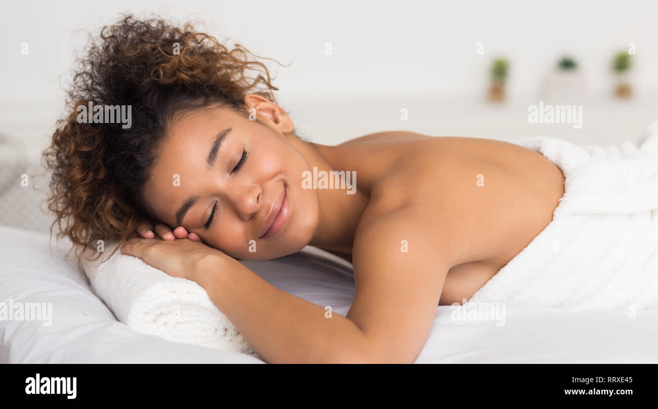 Happy african-american woman relaxing in light spa salon Banque D'Images