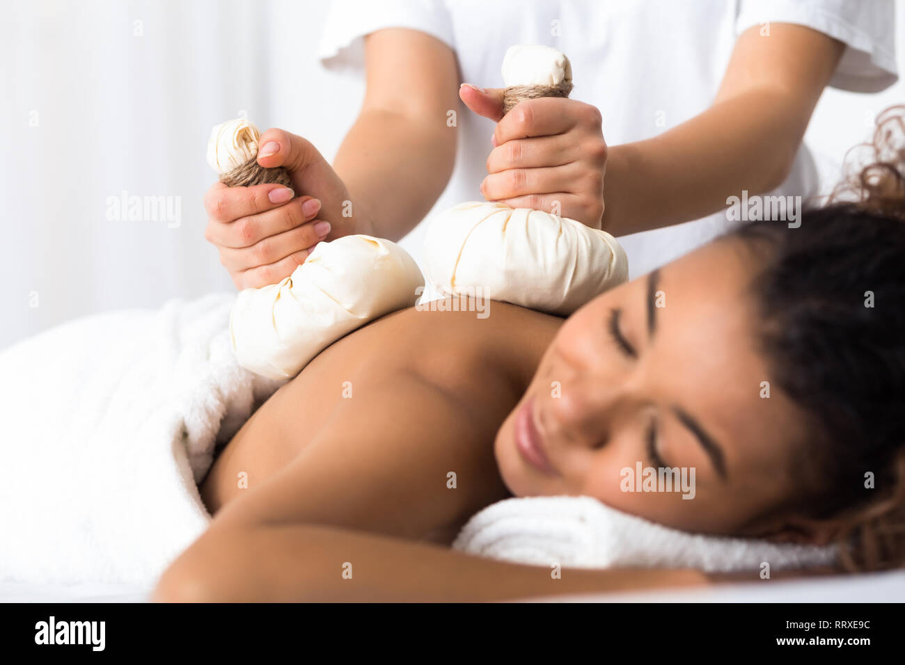 Femme ayant herb compress massage au spa de beauté Banque D'Images