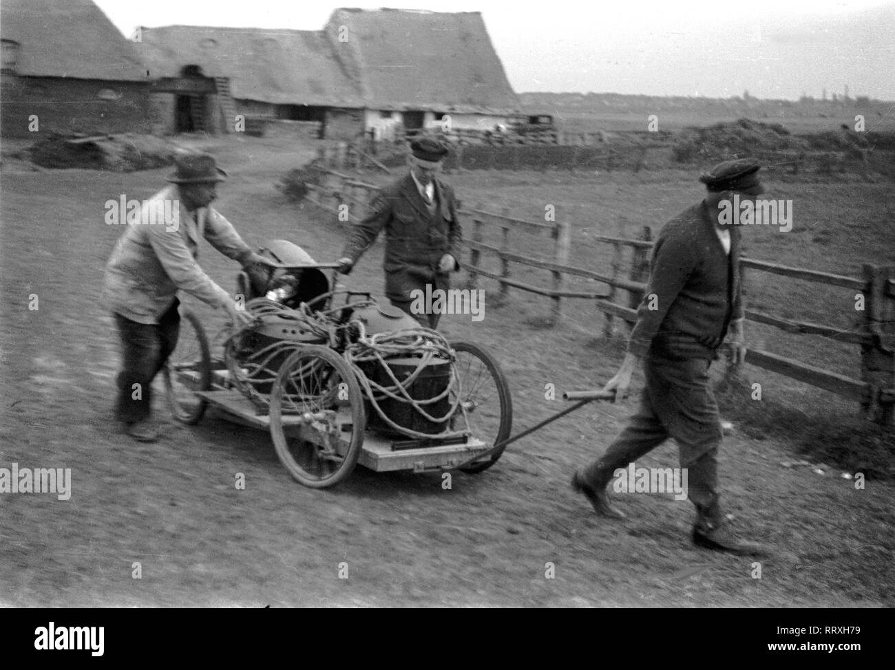 DER SCHIMMELREITER - Trois hommes transportent l'équipement de film avec une main- panier à l'endroit du film, 10/1933, I.12/24-8 Schimmelreiter Banque D'Images