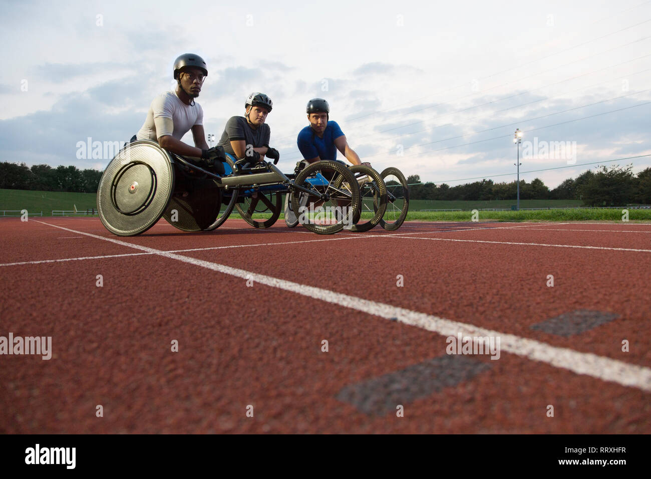 Portrait de la formation des athlètes paraplégiques déterminé pour la course sur piste de sports en fauteuil roulant Banque D'Images