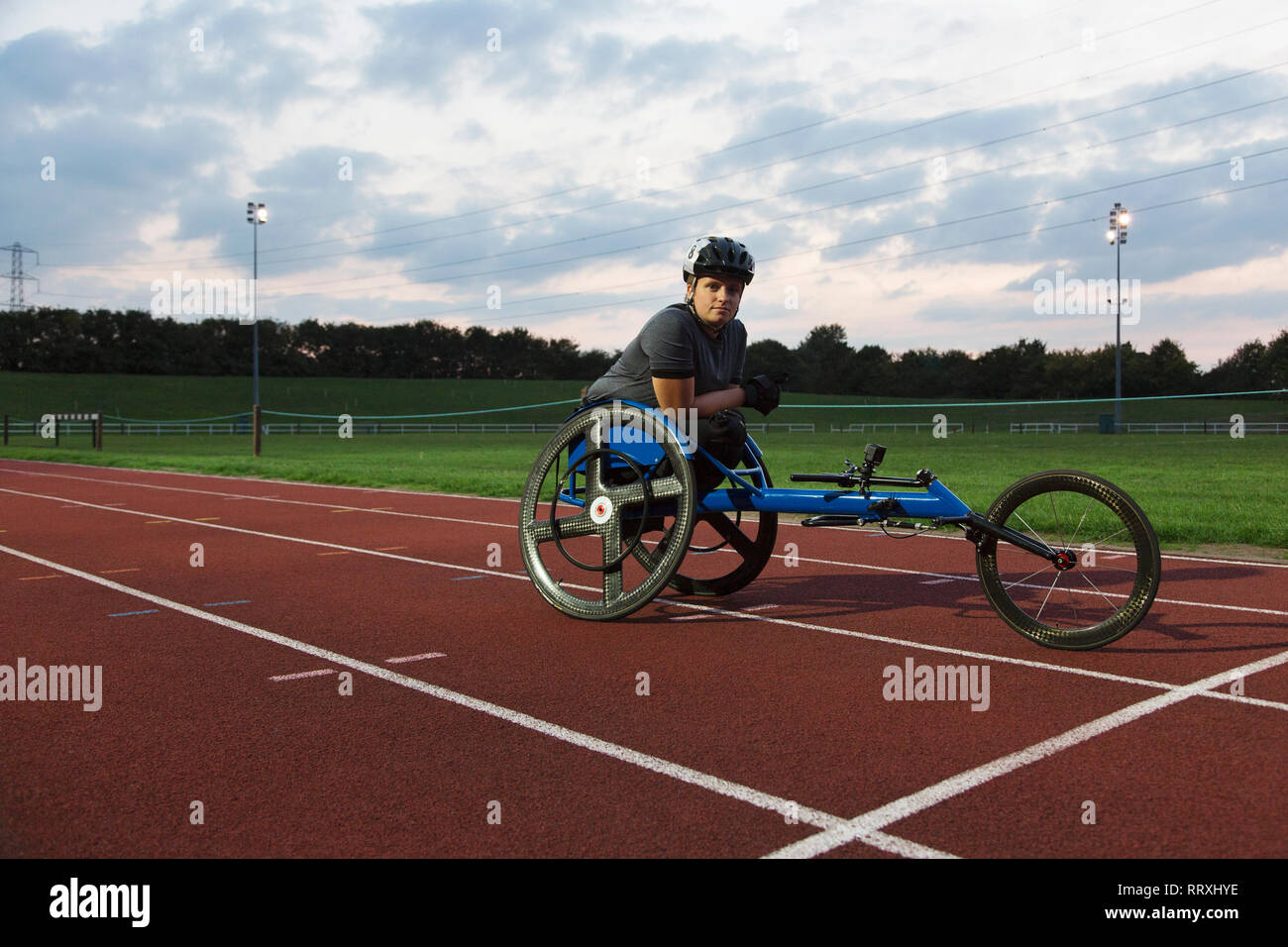 Confident female portrait athlète paraplégique en fauteuil roulant pour la formation sur piste de course sports Banque D'Images