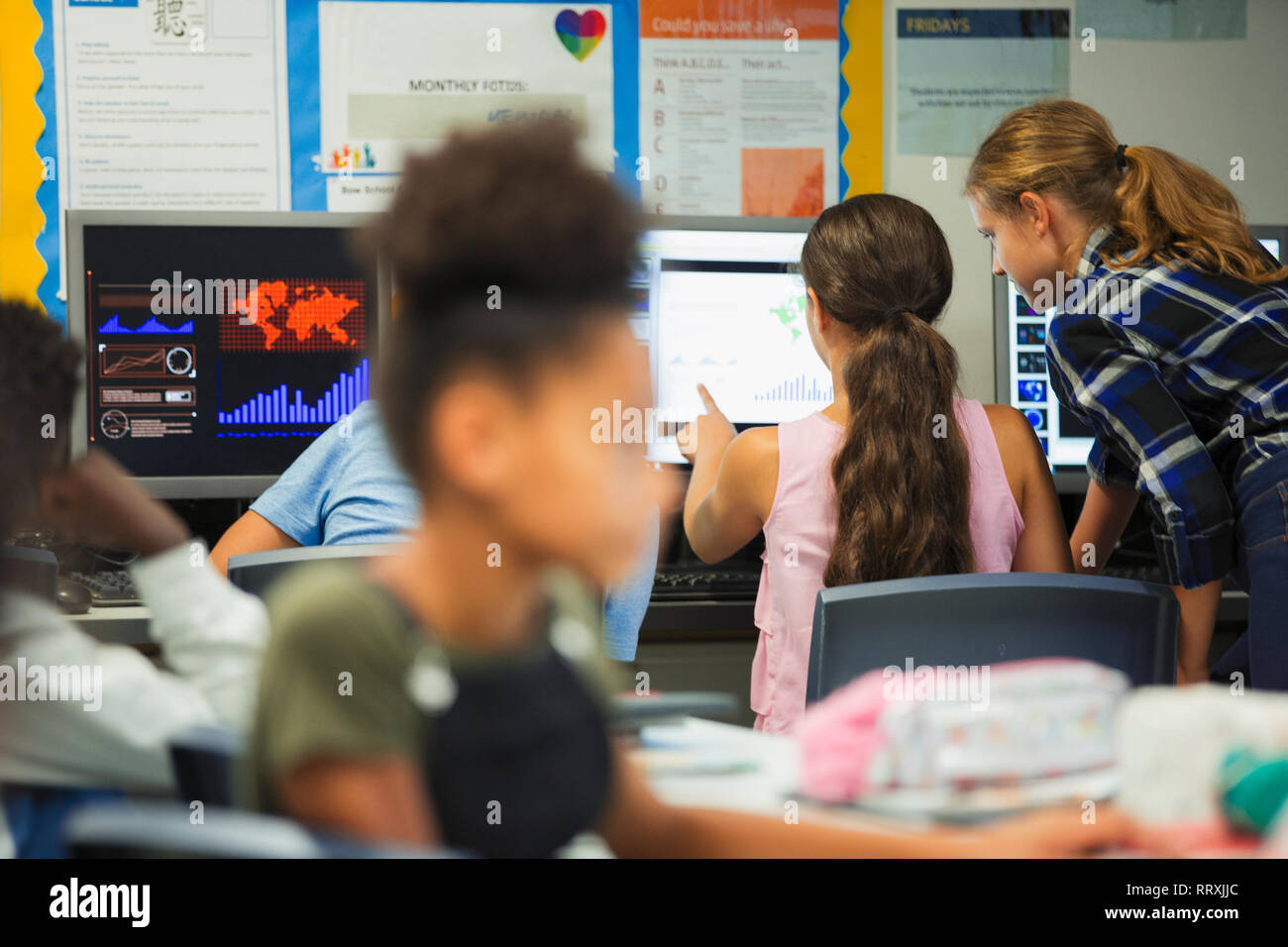 Junior High school girl élèves à l'aide de computer in classroom Banque D'Images