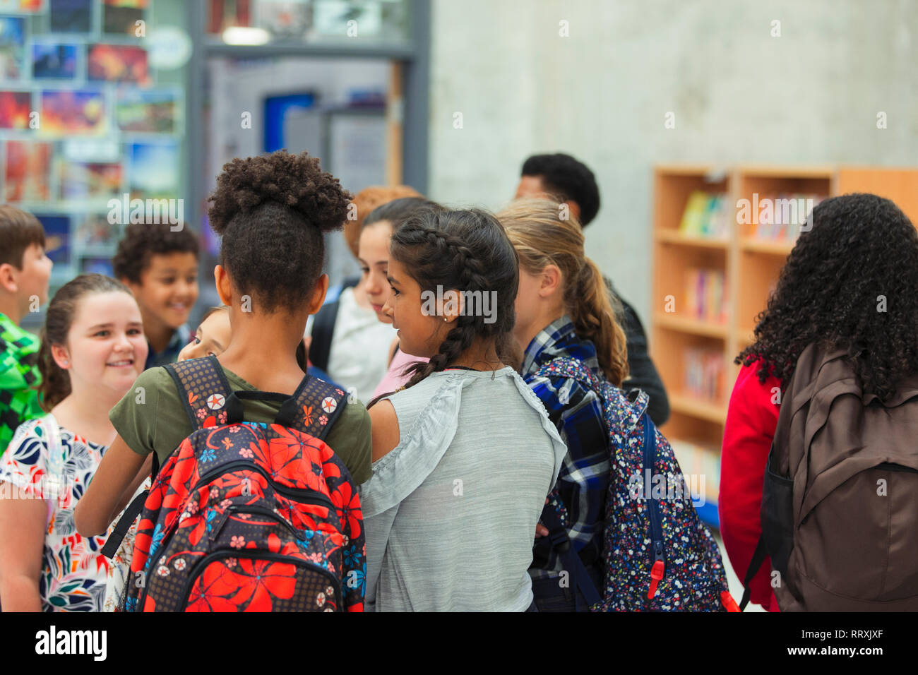 Junior High girl students talking in library Banque D'Images