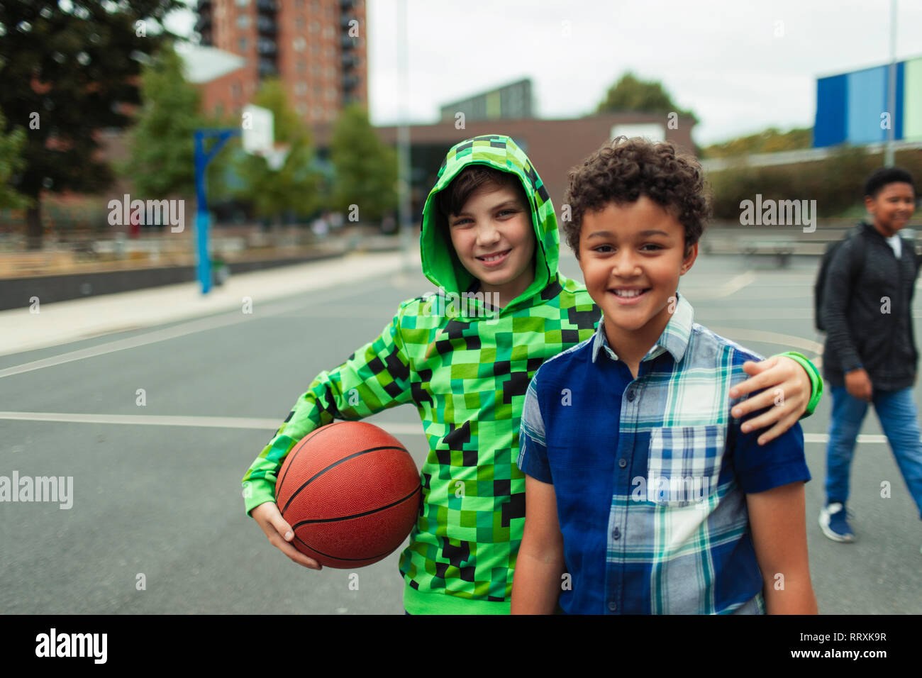 Portrait heureux junior high boy amis jouant au basket-ball à l'école Banque D'Images