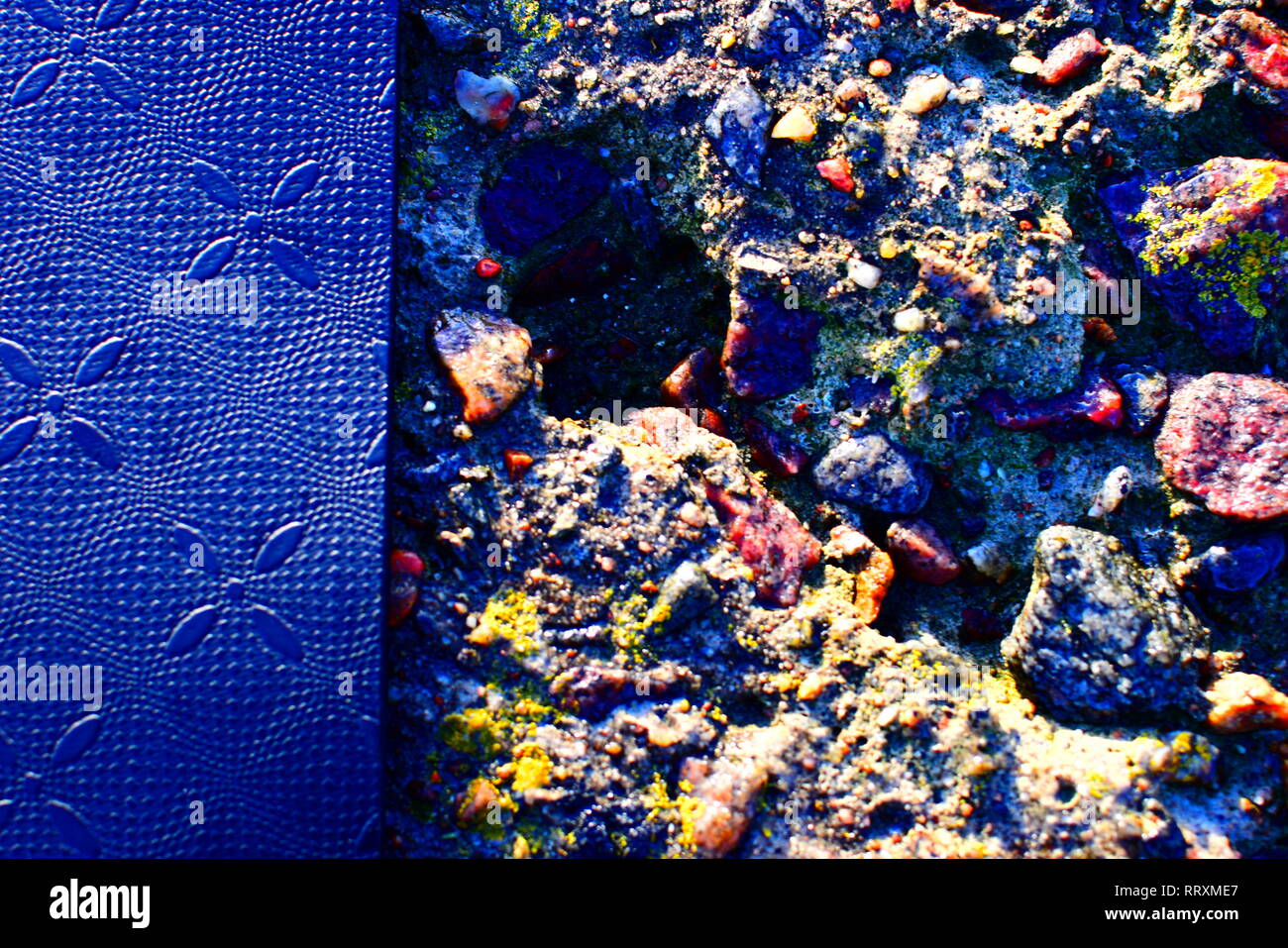 Le nouveau tapis de yoga à la terre noire avec des motifs dans le caoutchouc, tourné pendant une forte lumière du soleil à la plage par la mer Banque D'Images